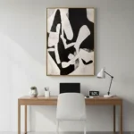 Gestural abstract hand-painted canvas in bold black and cream, dynamic organic forms, contemporary workspace