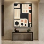 Minimalist abstract hand-painted canvas with geometric shapes, bold black lines, terracotta rectangles and circles on cream, contemporary entryway