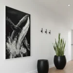 Monochromatic hand-painted canvas depicting breaching whale with dynamic splashing water in black and white, modern hallway