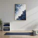 Contemporary landscape hand-painted canvas depicting snow-capped mountains and dramatic clouded sky in deep blues and whites, yoga studio setting