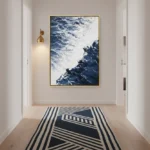 Contemporary landscape hand-painted canvas depicting dramatic ocean and cloud formations in deep blues and whites, modern entryway