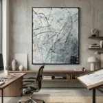 Abstract expressionist hand-painted canvas with gestural black lines and spattered details in monochrome grays, contemporary office space