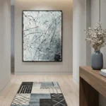 Abstract expressionist hand-painted canvas with gestural black lines and splattered details in monochrome greys, contemporary hallway setting