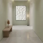 Textured abstract hand-painted canvas with embossed botanical leaf motifs in ivory and cream, minimalist entryway