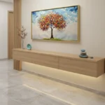 Impressionist hand-painted canvas depicting a vibrant autumn tree with multicolored foliage in warm reds, oranges, and yellows against a soft blue sky, contemporary interior setting