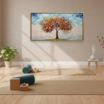 Impressionist hand-painted canvas depicting a vibrant autumn tree with orange and red foliage against cloudy sky, yoga studio setting