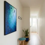 Contemporary abstract hand-painted canvas depicting divers in luminous turquoise and deep blue ocean tones, hallway setting