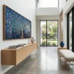 Gestural abstract hand-painted canvas with luminous tree and scattered brushstrokes in deep blue and gold, contemporary living space