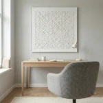 Textured minimalist hand-painted canvas in layered white and cream relief, contemporary workspace