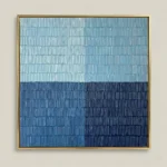 Minimalist hand-painted canvas with horizontal color blocks transitioning from pale blue to deep navy, contemporary living space