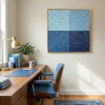 Layered abstract hand-painted canvas in segmented light and deep blue tones, contemporary office setting