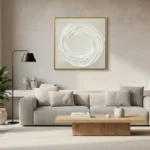 Gestural abstract hand-painted canvas with concentric white brushstrokes forming a spiral vortex, cream and ivory tones, contemporary living space