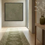 Minimalist hand-painted canvas depicting scattered birds in flight, soft sage and cream palette, contemporary hallway