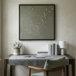 Minimalist hand-painted canvas depicting a flock of birds in flight, soft grey and white tones, contemporary workspace