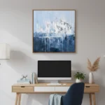 Layered abstract hand-painted canvas depicting an ethereal cityscape in cool blues and whites with dripping vertical elements, styled in contemporary workspace