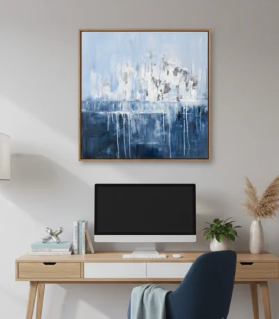 Layered abstract hand-painted canvas depicting an ethereal cityscape in cool blues and whites with dripping vertical elements, styled in contemporary workspace