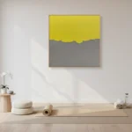 Minimalist abstract hand-painted canvas with yellow sky and grey horizon in soft, muted tones, styled in contemporary space