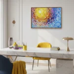 Gestural impressionist hand-painted canvas depicting a swirling yellow sun in vibrant rainbow brushstrokes, contemporary workspace