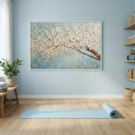 Textured hand-painted canvas depicting white cherry blossoms on brown branch against soft blue palette, yoga studio setting