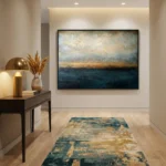 Layered abstract landscape hand-painted canvas in muted ocean blues, warm sand, and cream tones, contemporary entryway
