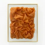 Textured abstract hand-painted canvas in rich burnt orange with sculptural fabric folds and dimensional layering
