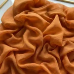 Textured abstract hand-painted canvas in warm terracotta and burnt orange, with dimensional gestural folds and layered brushwork