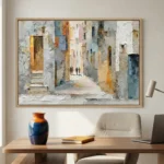 Impressionist hand-painted canvas depicting a narrow European alleyway with weathered stone buildings in cream, ochre and soft blue tones, contemporary office setting