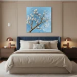 Contemporary hand-painted canvas depicting flowering cherry blossom branch against soft blue sky, cream and gold tones, modern bedroom