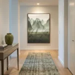 Contemporary landscape hand-painted canvas depicting misty mountains and windswept grasses in soft green and grey tones, modern entryway