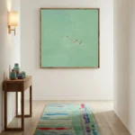 Minimalist figurative hand-painted canvas depicting three swimmers in turquoise water, soft aqua palette, modern hallway setting