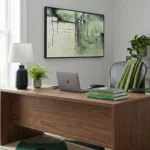 Layered abstract hand-painted canvas in muted greens and creams with gestural marks, contemporary office setting