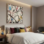 Gestural abstract expressionist hand-painted canvas with dynamic black lines and bold red, blue, yellow accents on cream, modern bedroom