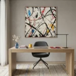 Gestural abstract expressionist hand-painted canvas with dynamic black lines and vibrant red, blue, and yellow accents on cream, modern office setting