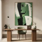 Contemporary abstract hand-painted canvas in bold green and black geometric forms with cream accents, modern workspace