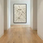 Textured abstract hand-painted canvas with radiating cream and taupe brushstrokes creating dimensional focal points, contemporary gallery space