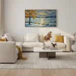 Impressionist landscape hand-painted canvas depicting golden tree beside frozen lake in cool blues and warm amber tones, contemporary living space