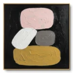Minimalist painting of stacked organic stone shapes in pink, white, grey and mustard on black, gold thin frame