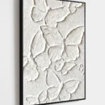 Plaster Wings textured wall art shown framed on the wall in a styled interior