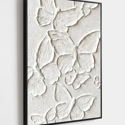 Plaster Wings textured wall art shown framed on the wall in a styled interior