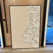 Textured abstract hand-painted canvas with organic sculptural relief forms in cream and ivory tones, contemporary office setting