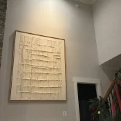 Textured abstract hand-painted canvas in cream and ivory with layered linear marks, contemporary stairwell